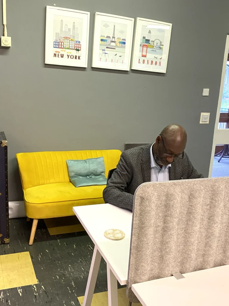 Client reading notes on sofa near yellow wall and framed prints