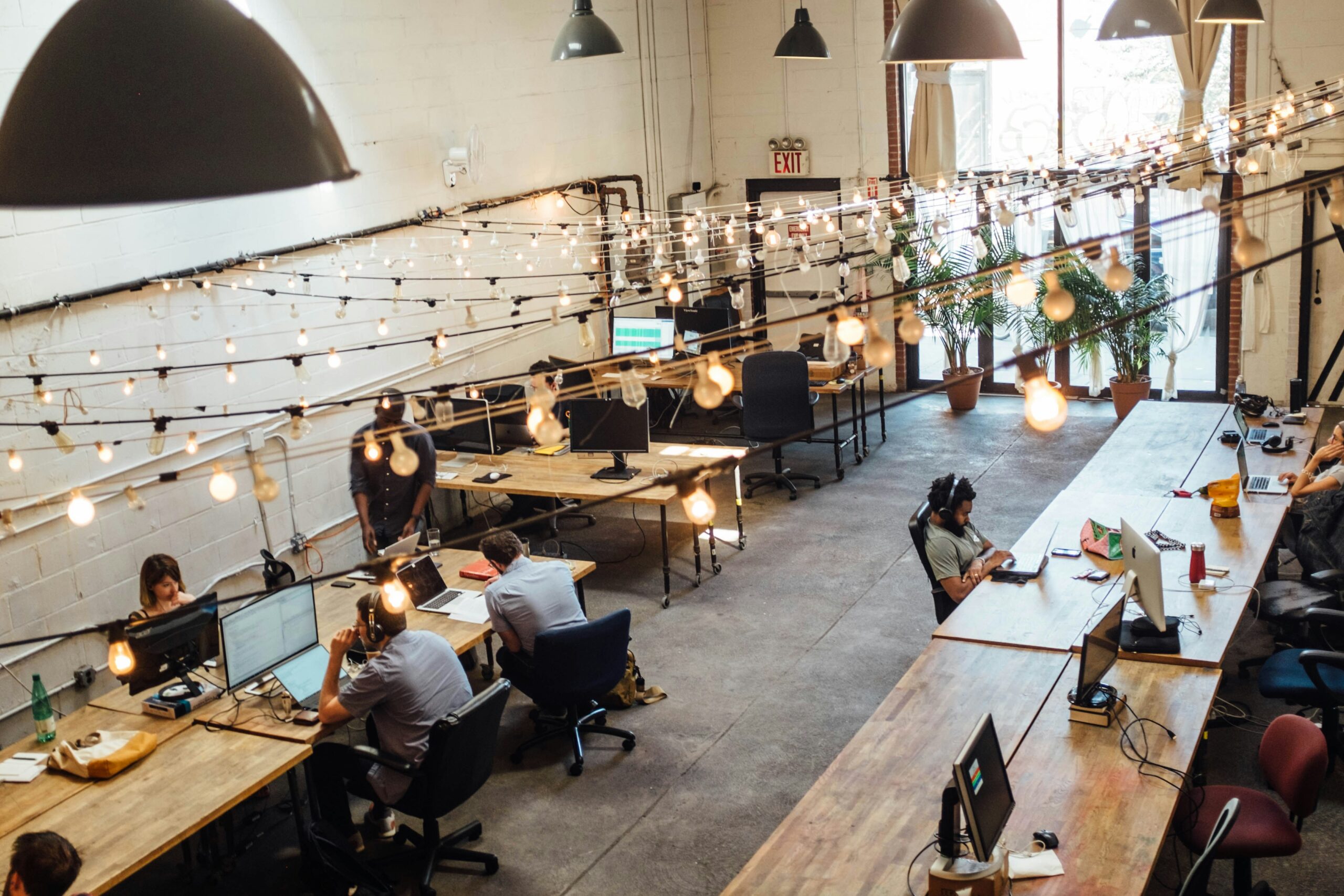 Ariel shot of a coworking space with long wooden desks and industrial decor.