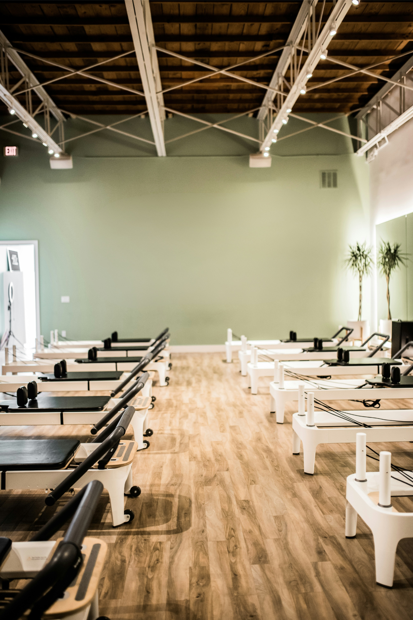 Spacious modern Pilates studio with reformer machines and wooden flooring in a fitness centre